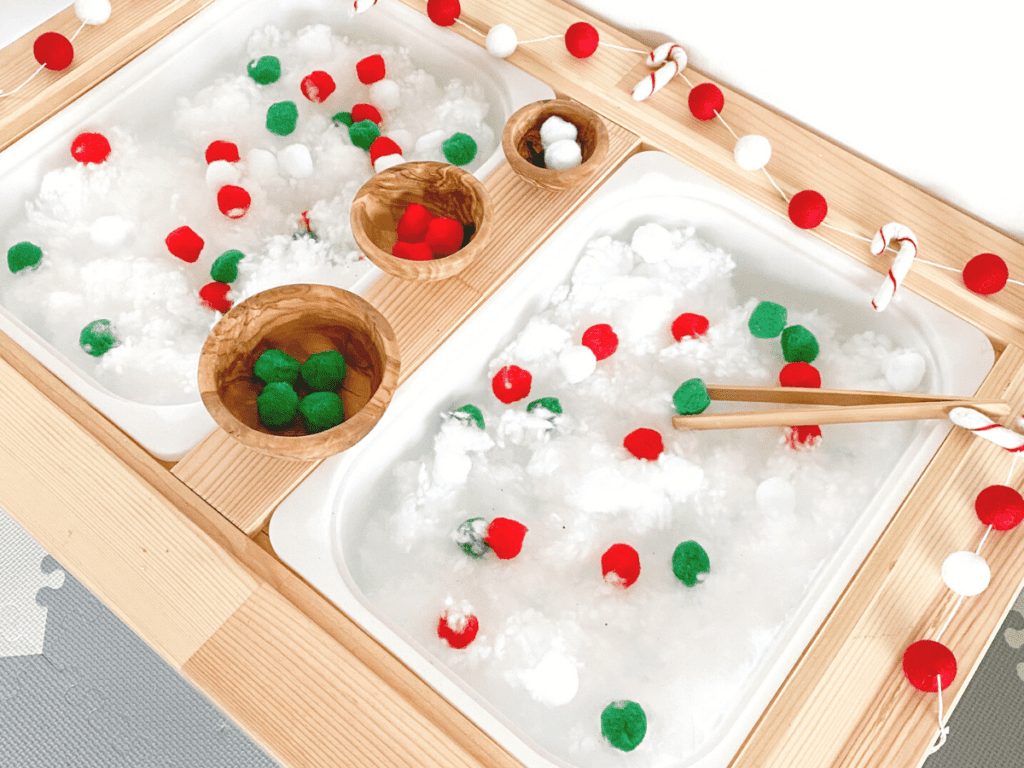 Christmas sensory bin idea using fake snow and pompoms. This bin is great to work on patterning, sorting skills. It's a great fine motor activity!