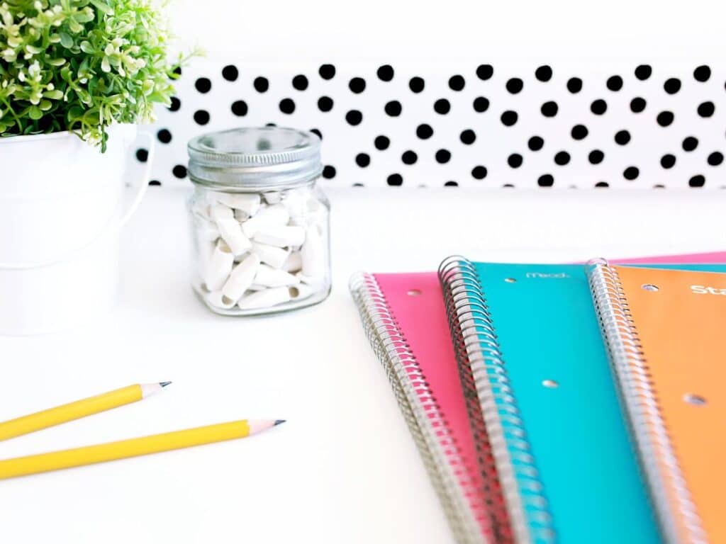 Notebooks, pencils, and erasers on a desk